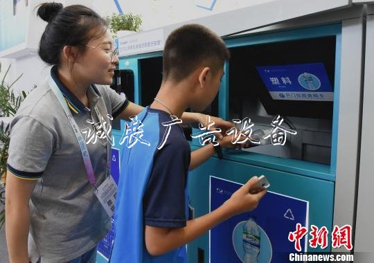 圖為小朋友感受用智能垃圾箱掃碼扔垃圾。　周毅　攝