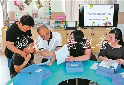 無錫市廣新小學校長過秦勇（右三）、副校長朱甄珍（右一）與梁溪區(qū)特教指導中心資源教師陳向華（右二），和學生小芮及家長一起商量個別化教育方案。