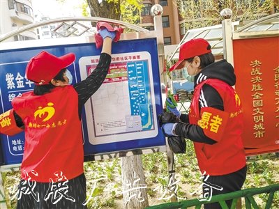 市第十一小學志愿者在擦拭宣傳欄。 本報記者 張?zhí)鸶?攝