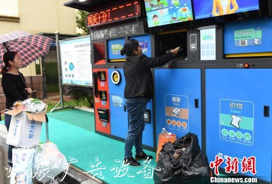 圖為市民在智能化垃圾箱根據(jù)類別投放垃圾。　周毅 攝